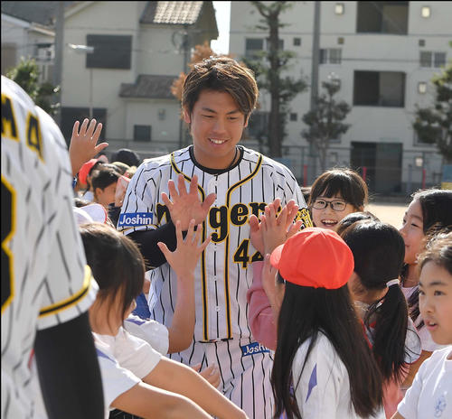 児童らとハイタッチする梅野隆太郎（撮影・上田博志）