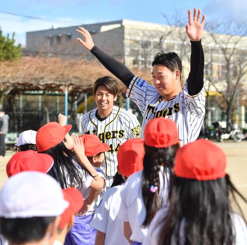 小学校を訪問した大山（右）と梅野は児童の出迎えに笑顔を見せる（撮影・上田博志）