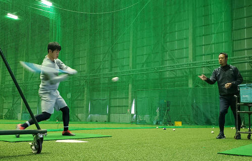 オリックス太田（左）は打撃投手を務める父暁さんが上げるトスでティー打撃を行う