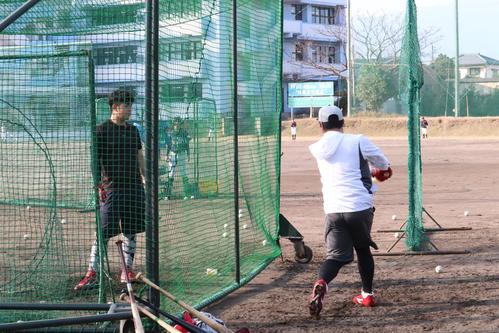 打撃ケージ内の林（左）に実践しながら打撃指導する松山（撮影・前原淳）