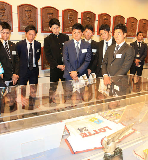 展示されている故・金田正一氏のユニホームに見入る佐々木朗（左から3人目）らロッテの新人選手たち