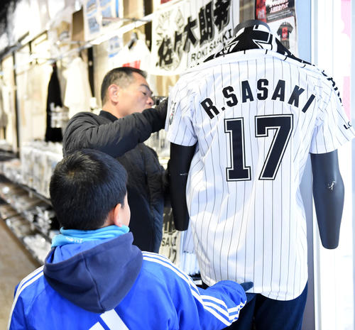 ロッテ佐々木朗のグッズを確認するファン（撮影・横山健太）