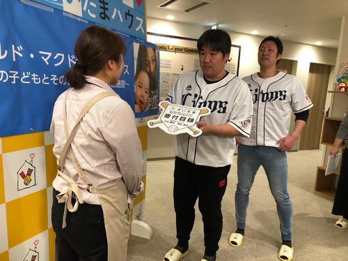 施設のスタッフに目録を手渡す西武中村（中央）と増田