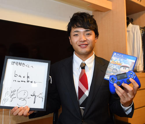 back　numberの色紙とゲームソフト「パワプロ」を手に入寮した郡司裕也（2020年1月8日撮影）