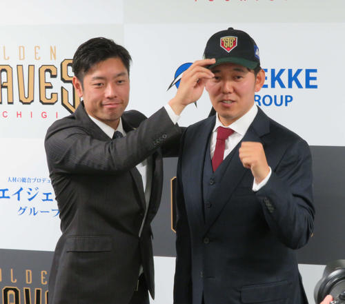 BC栃木の入団会見で元巨人の寺内監督から帽子をかぶせてもらう成瀬（右）