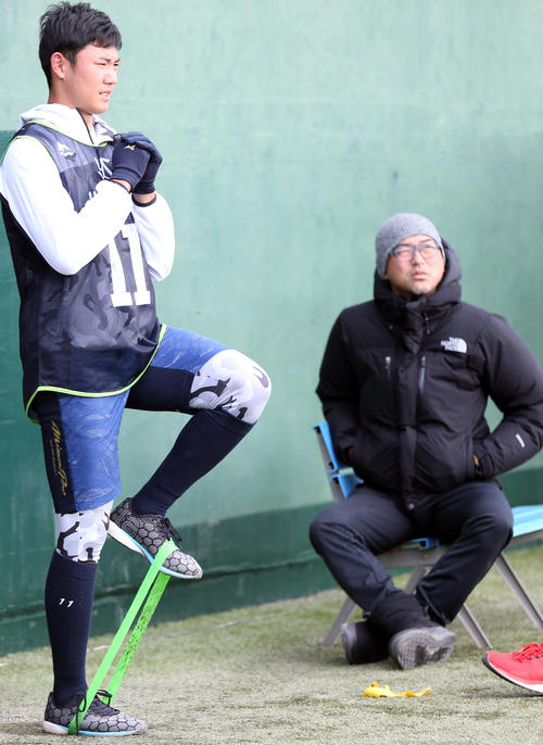 右肘の軽い炎症のためノースロー調整となり、斎藤投手コーチ（右）の横で体幹トレーニングをする奥川（撮影・狩俣裕三）