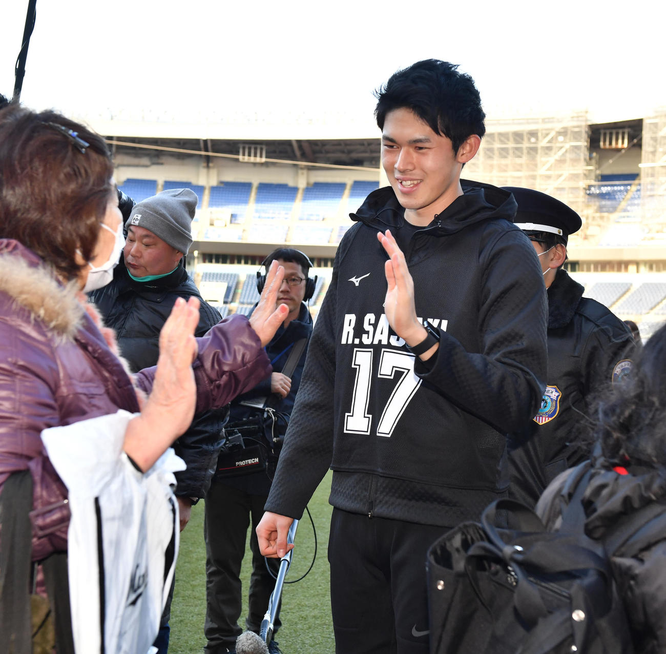 新人合同自主トレを終えた佐々木朗（右）は約600人とハイタッチする（撮影・柴田隆二）