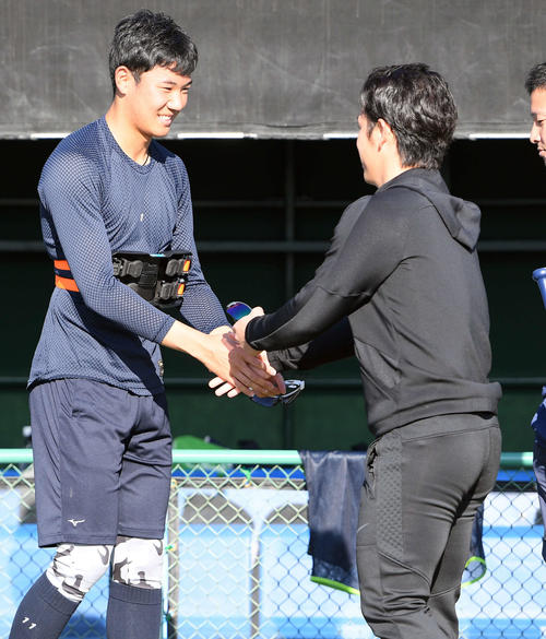 小川泰弘（右）と笑顔で握手を交わすヤクルトドラフト1位の奥川恭伸（撮影・たえ見朱実）