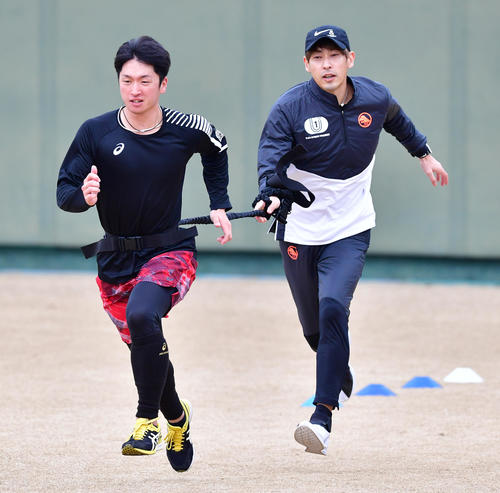 秋本真吾氏（右）のスプリント指導で腰にゴムチューブを巻きダッシュする阪神近本（撮影・清水貴仁）