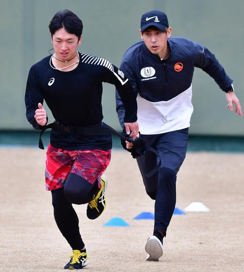 秋本真吾氏（右）のスプリント指導で腰にゴムチューブを巻きダッシュする阪神近本光司（撮影・清水貴仁）