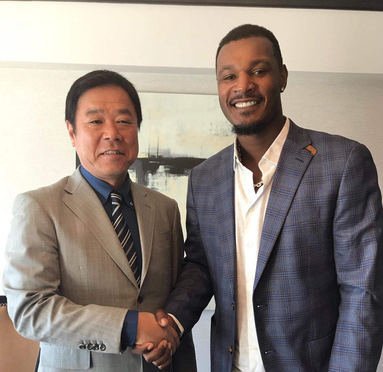 オリックス入りが決まり福良GM（左）と握手する新外国人のアダム・ジョーンズ（2019年12月11日撮影＝球団提供）
