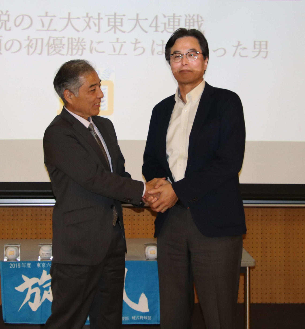 握手を交わす大山雄司さん（左）と野口裕美さん（東大野球部提供）