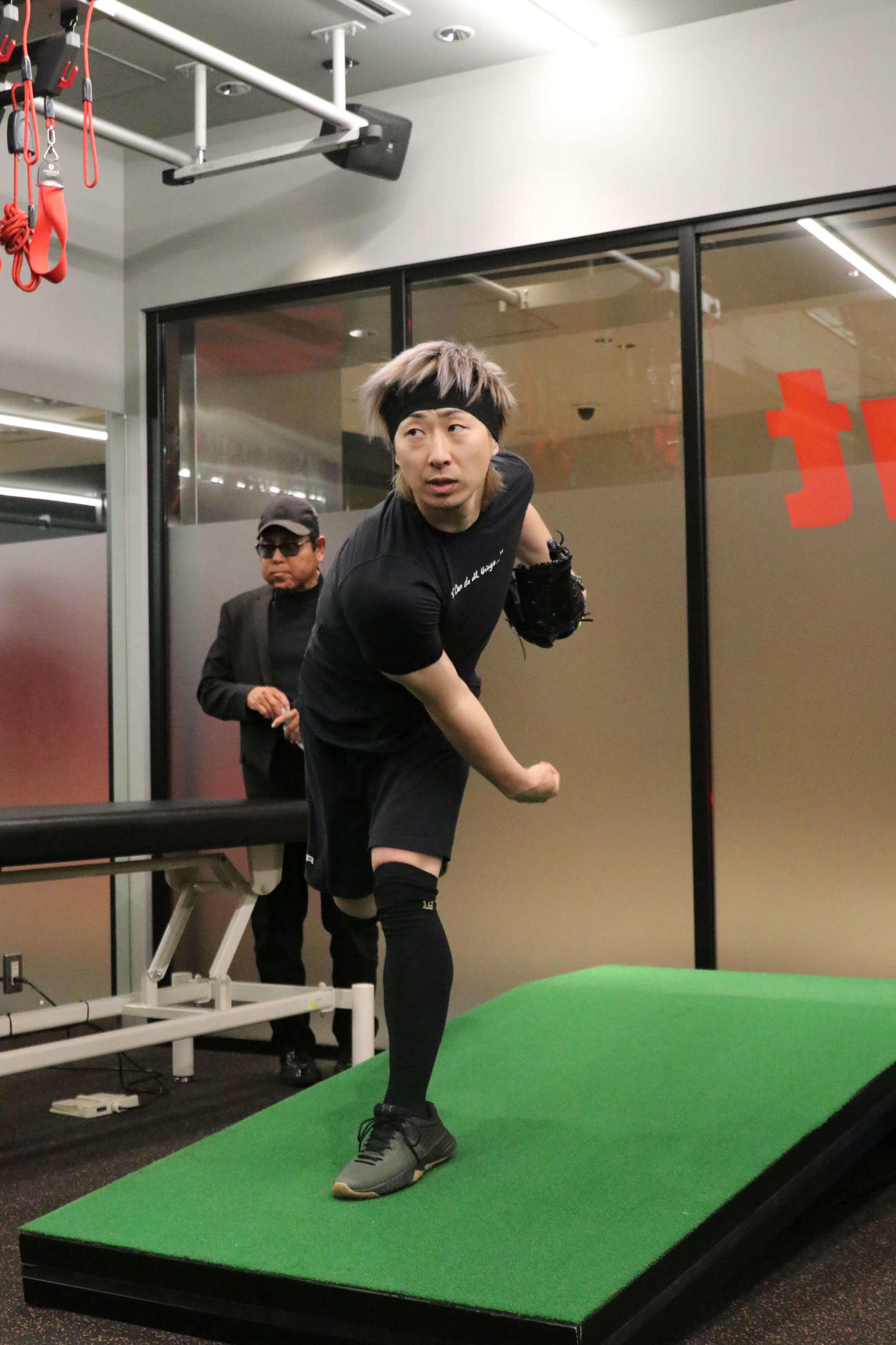 ケビン山崎氏（左奥）が見守る中、投球を行う日本ハム金子（撮影・山崎純一）