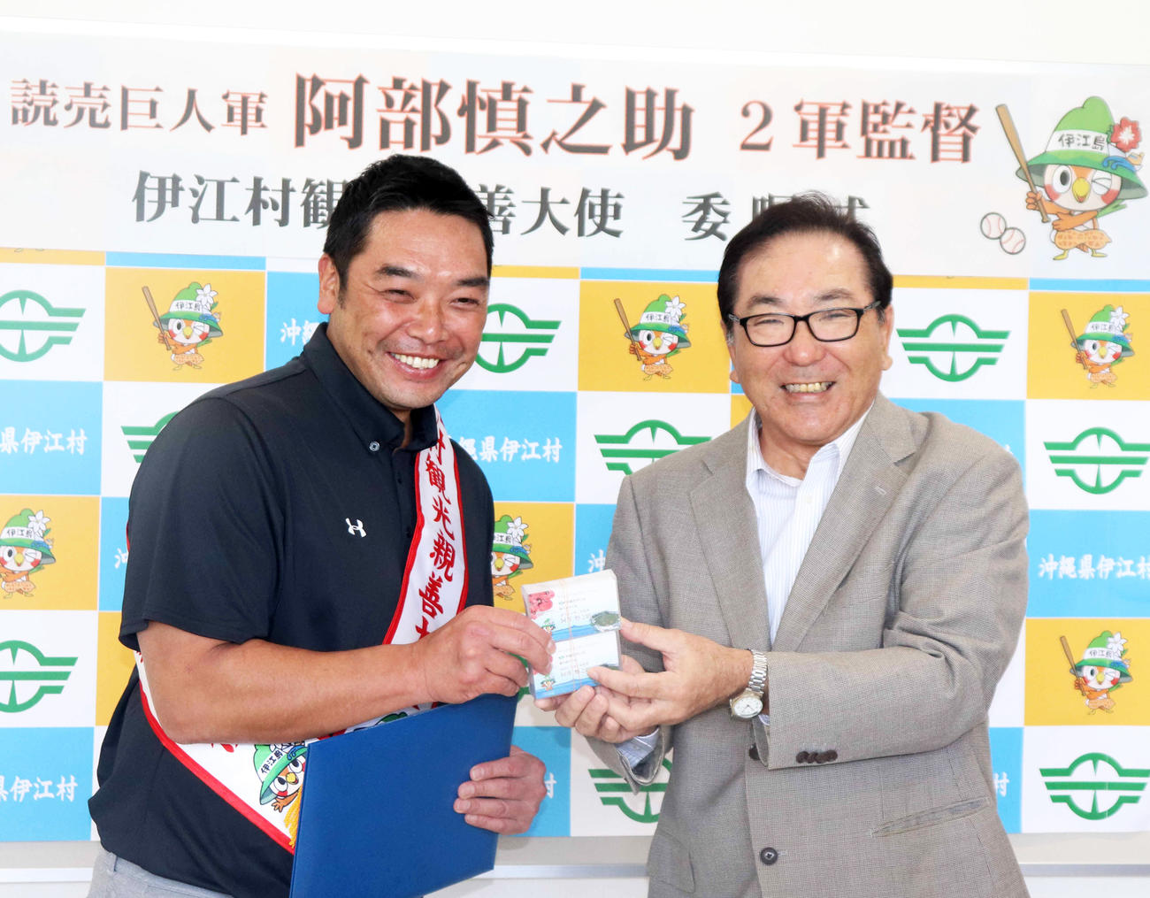 伊江村観光親善大使の名刺をもらい笑顔の巨人阿部2軍監督（左）と島袋村長（撮影・久永壮真）