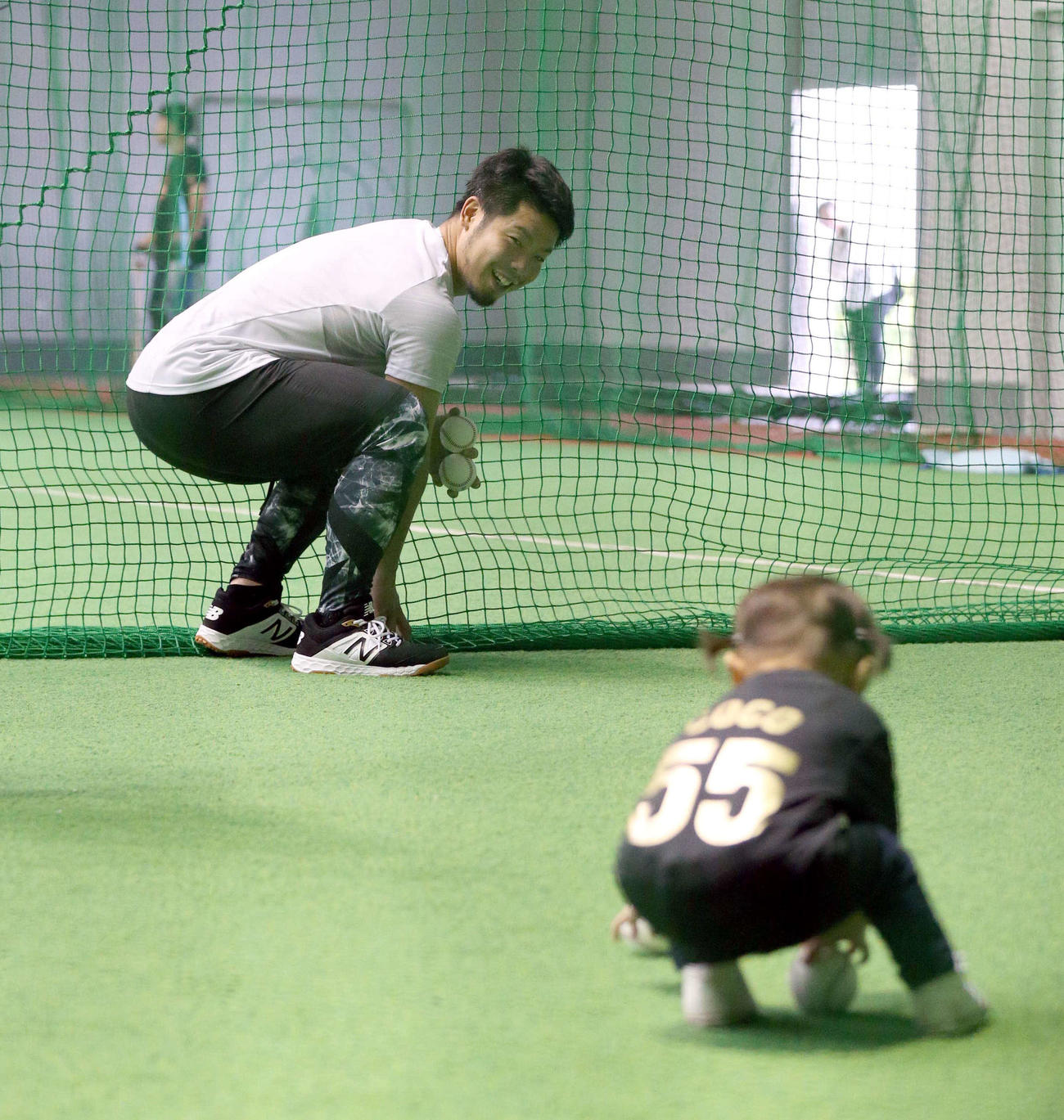 打撃練習後、球拾いをする関係者の子どもを笑顔で見つめる日本ハム近藤（撮影・黒川智章）