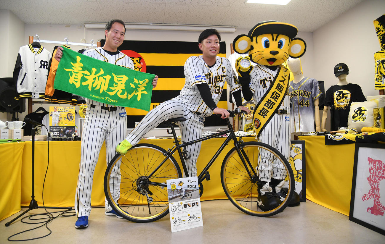 阪神タイガース新作グッズ内覧会でグッズを手に笑顔の左から青柳晃洋、糸原健斗、トラッキー（撮影・渦原淳）