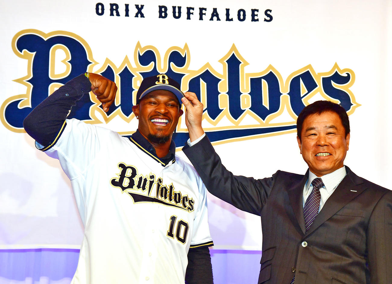 来日直後の入団会見でオリックスのユニホームに袖を通すジョーンズ。右は福良GM（撮影・清水貴仁）