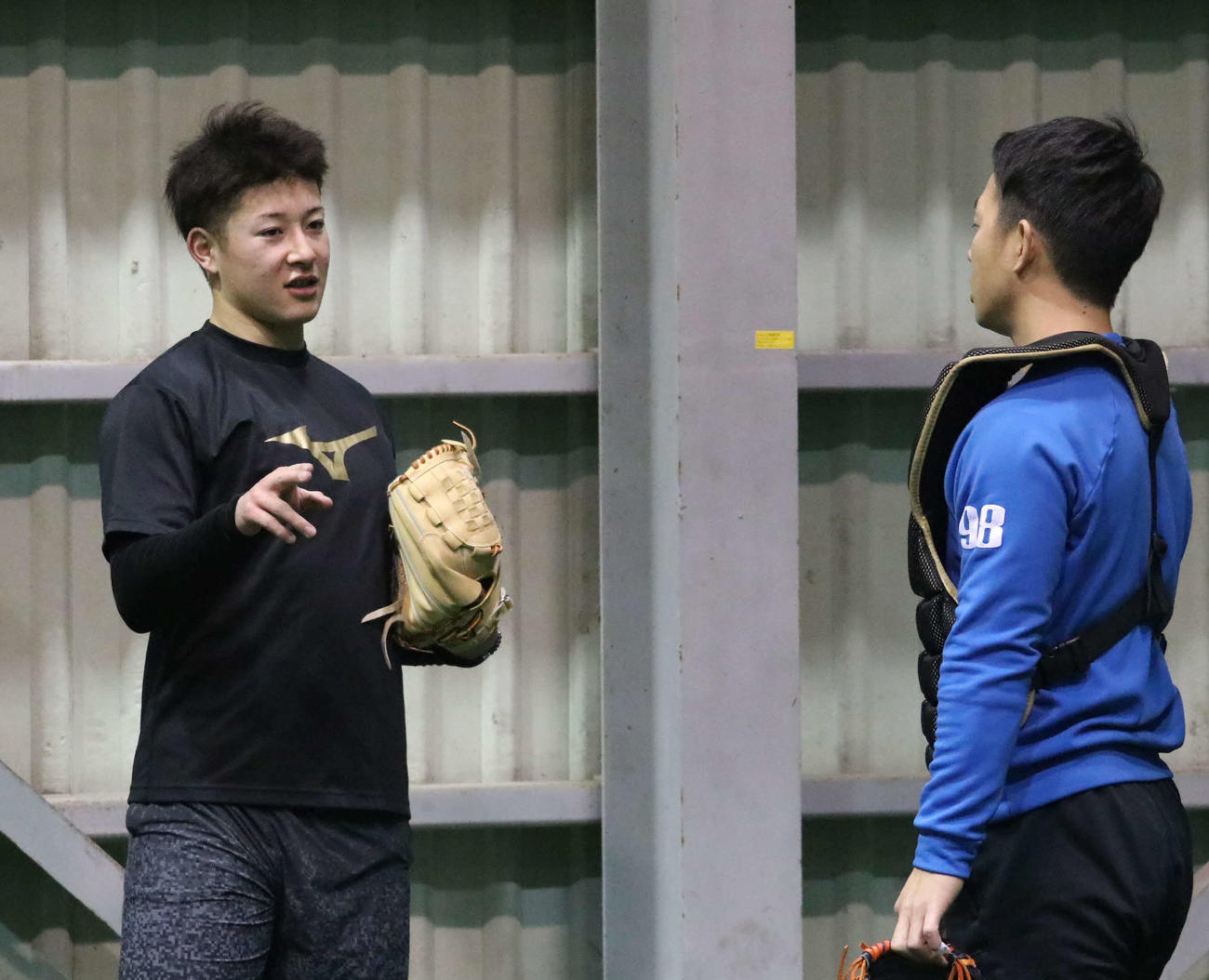 投球練習を終え、ブルペン捕手（右）と話す日本ハム吉田輝（撮影・山崎純一）