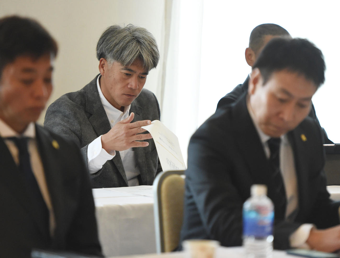 監督、コーチ会議に出席し書類に目を通す会長付特別アドバイザーの城島（撮影・今浪浩三）