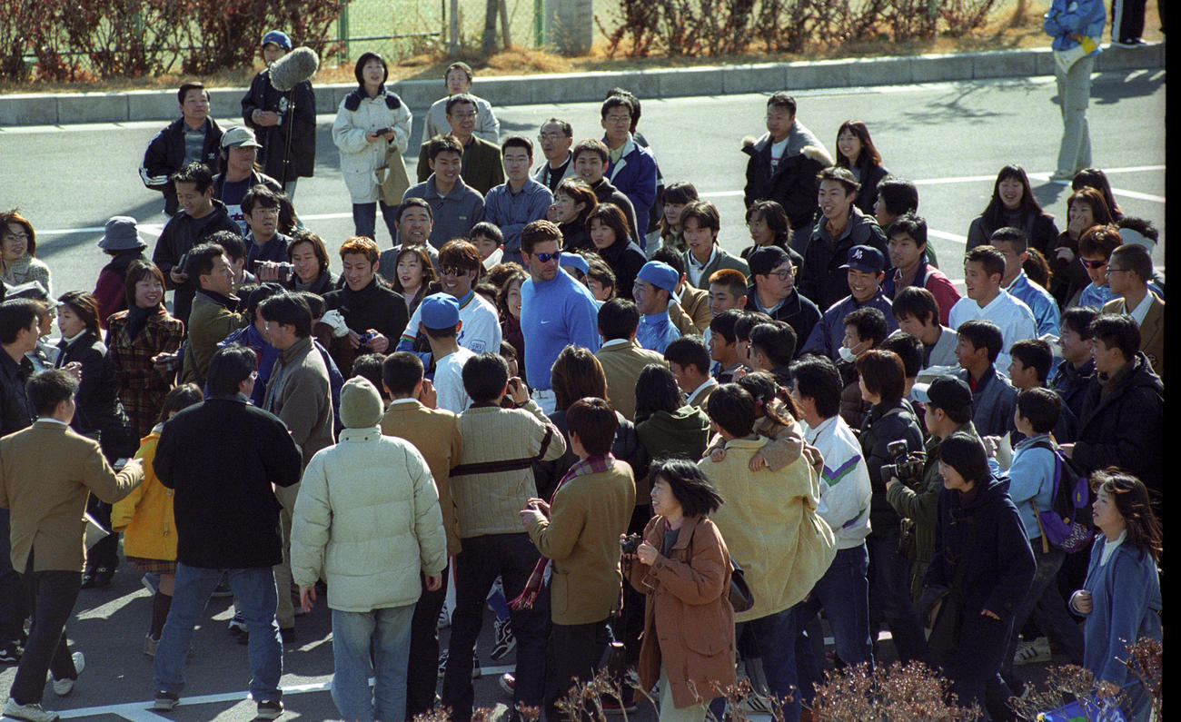 99年2月、西武春季キャンプ　多くのファンに囲まれながら移動する松坂（中央）。同左はデニー友利とテリー・ブロス