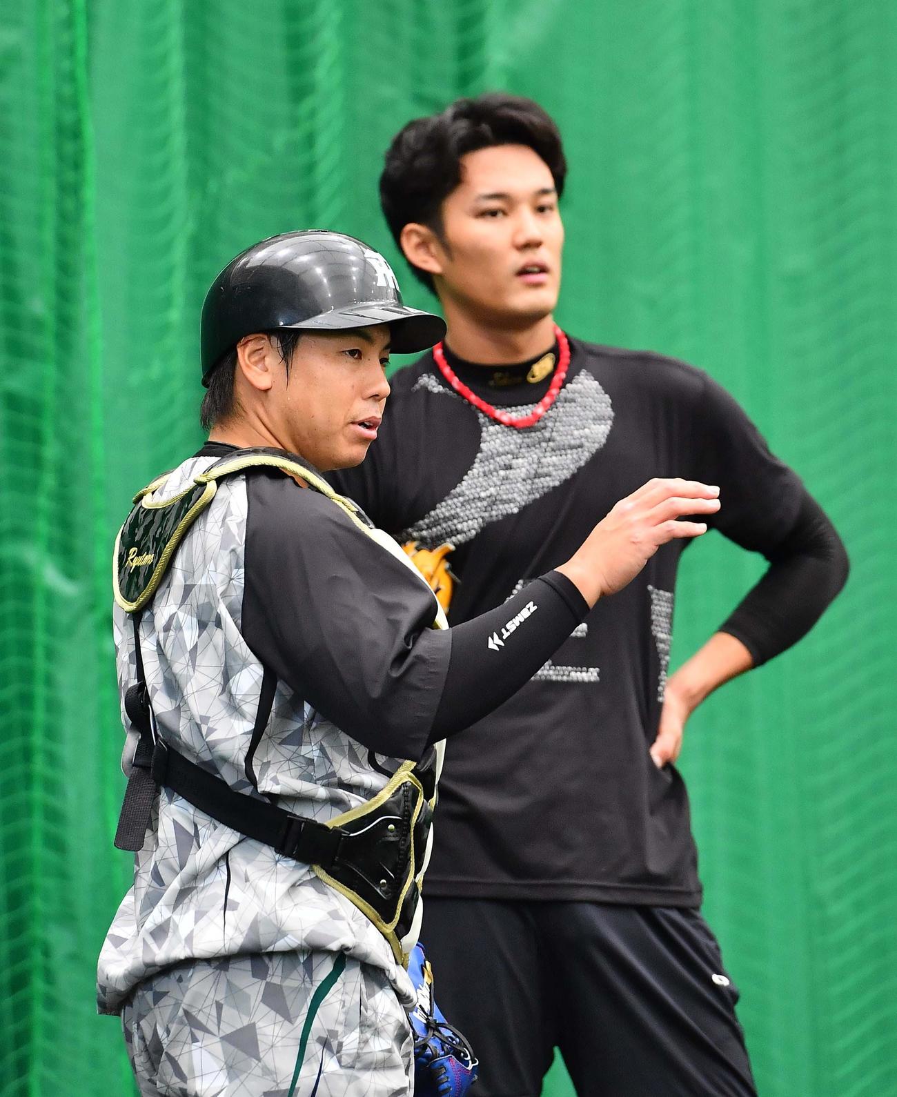 ブルペンで藤浪（右）と話す梅野（撮影・上田博志）