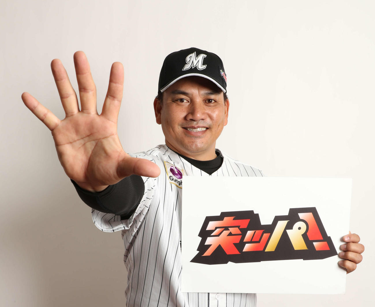 20年スローガン「突ッパ」を手に、ポーズをとる井口資仁監督（2019年12月28日撮影）