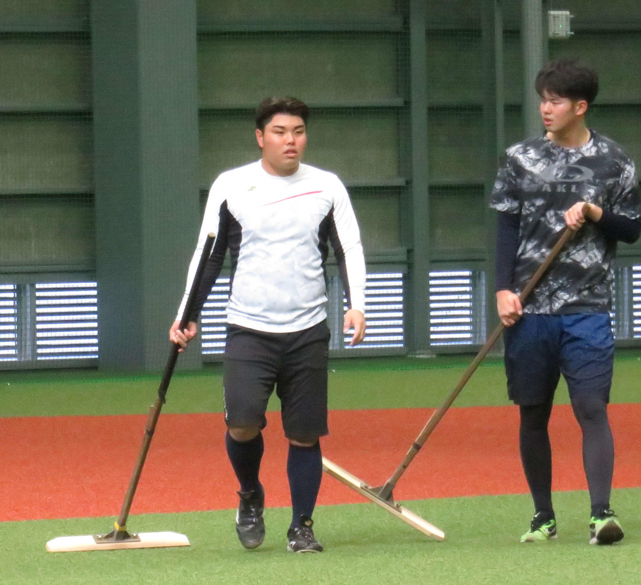 室内練習場を整備する西武平良（左）と渡辺（撮影・栗田成芳）
