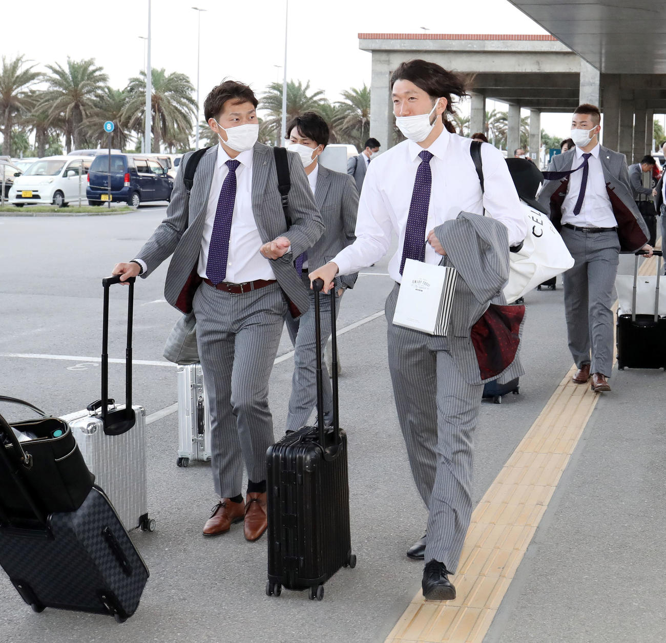 南ぬ島石垣空港に到着し移動バスに向かうロッテ石川（右）ら選手たち（撮影・垰建太）