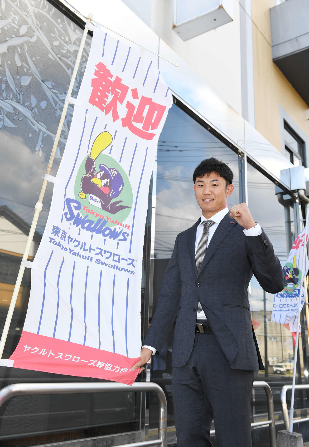 西都の宿舎に到着し、ガッツポーズするヤクルト奥川（撮影・鈴木みどり）