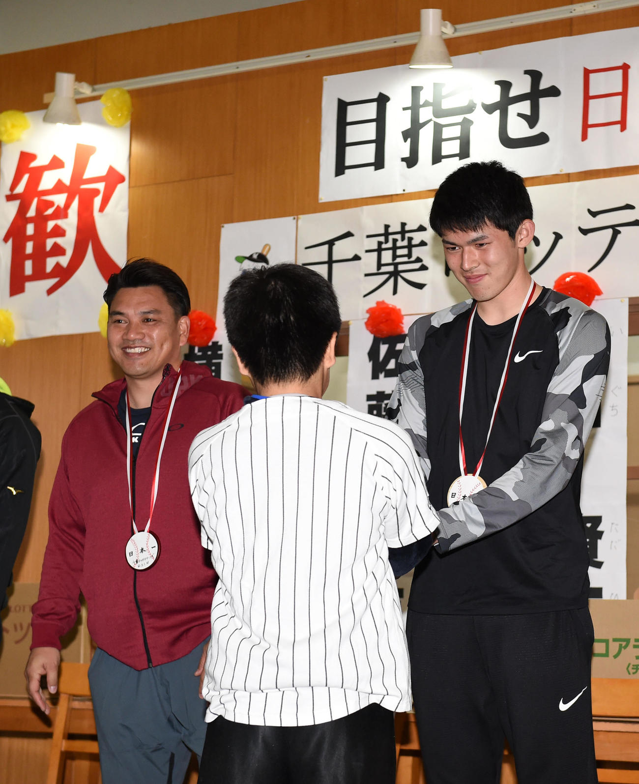 児童養護施設「ならさ」を訪問し子供たちと握手を交わすロッテ佐々木朗（右）。左は井口監督（撮影・横山健太）
