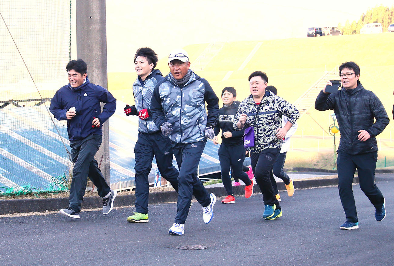 報道陣と早朝ランニングする西武辻監督（左から3人目）（撮影・足立雅史）