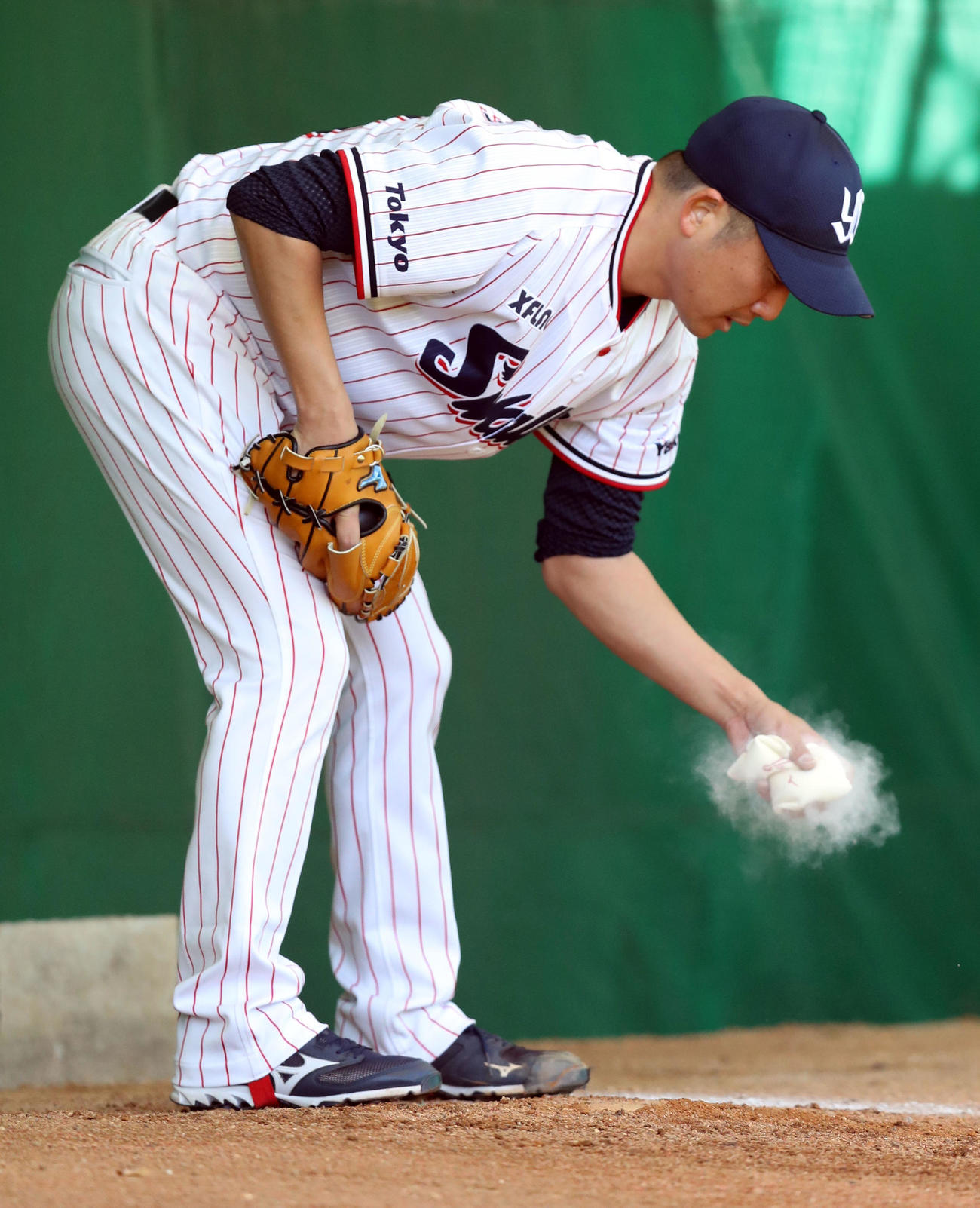 ブルペンで滑り止めを握りしめる石川（撮影・狩俣裕三）