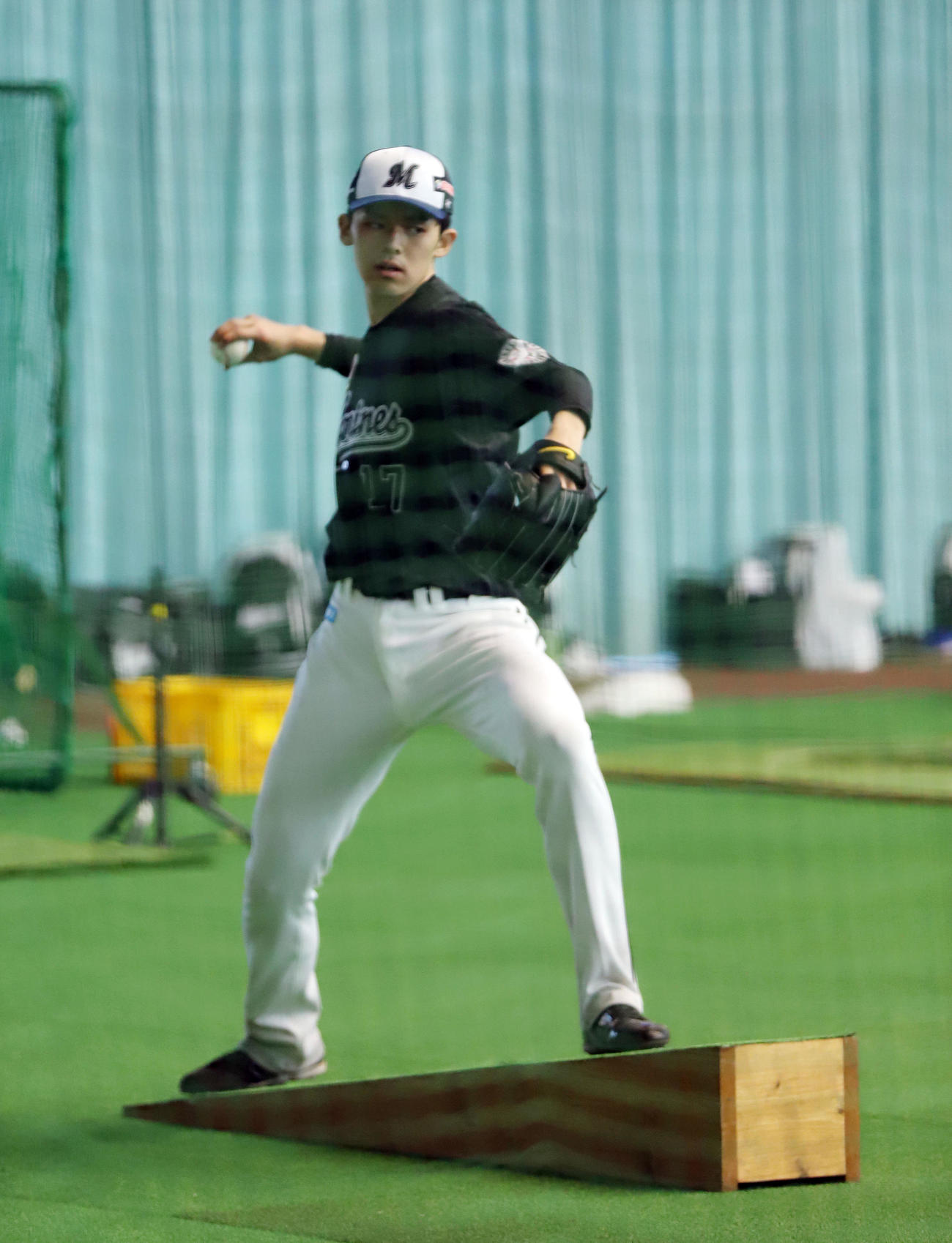 室内練習場で傾斜台に乗ってネットスローするロッテ佐々木朗（撮影・垰建太）