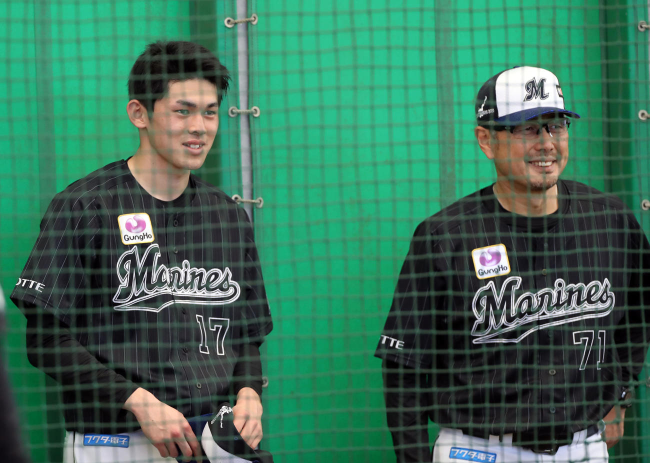 ブルペンを見学するロッテ佐々木朗（左）は吉井投手コーチと笑顔で言葉を交わす（撮影・垰建太）