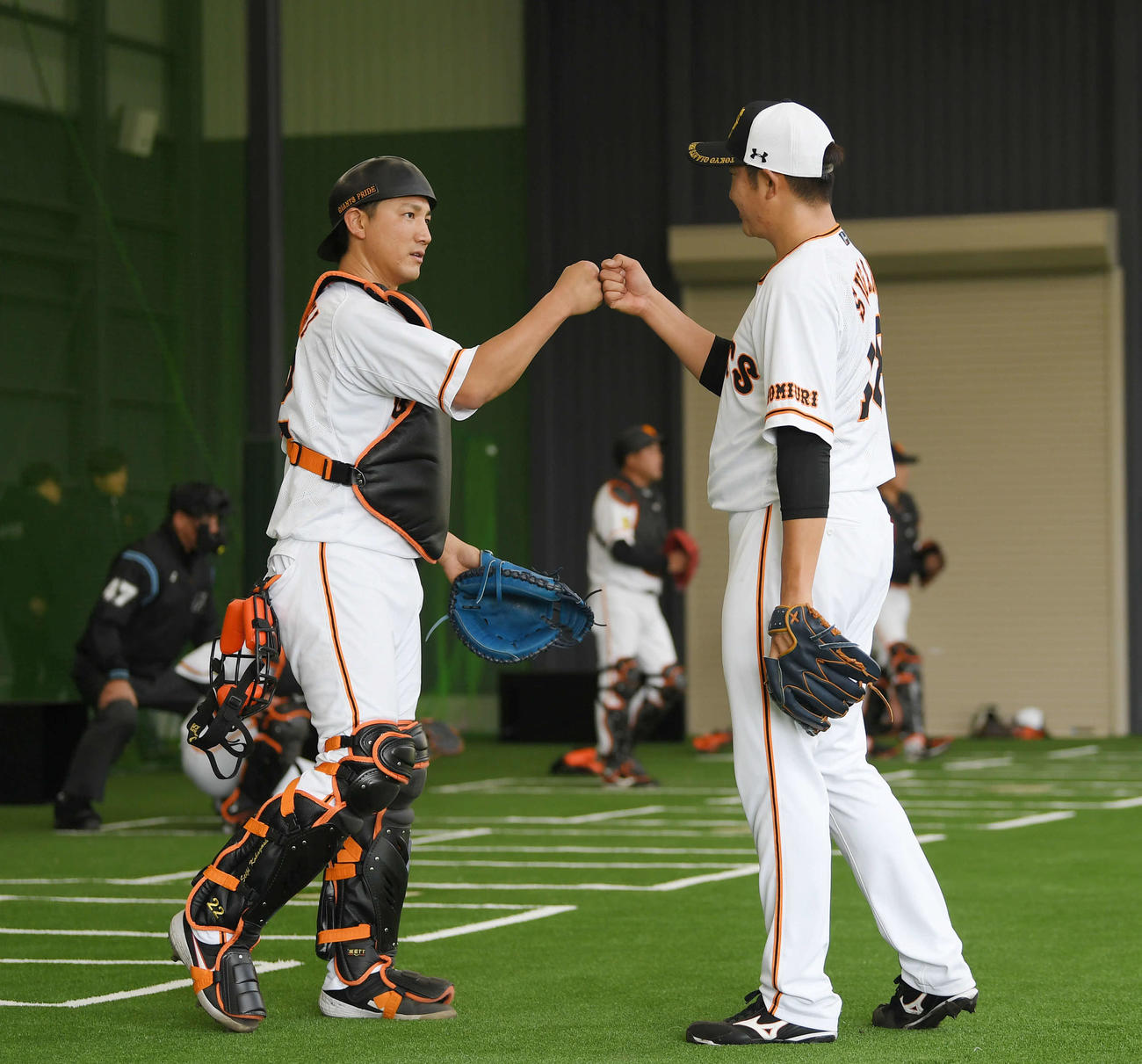 ブルペン投球を終え、巨人小林（左）とグータッチする菅野（撮影・加藤諒）