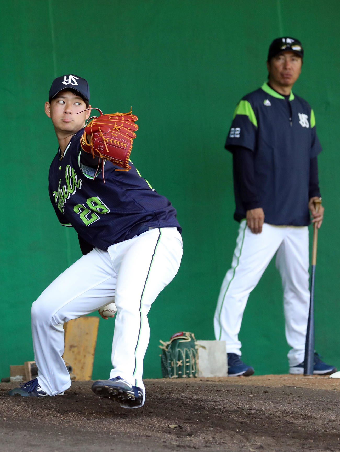 高津監督（後方）が見守る中、ブルペンで投げ込む吉田喜（撮影・狩俣裕三）