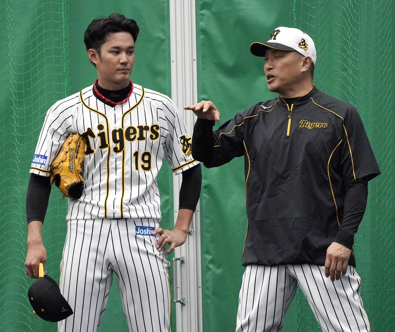 ブルペンで藤浪（左）を指導する山本昌臨時コーチ（撮影・上山淳一）