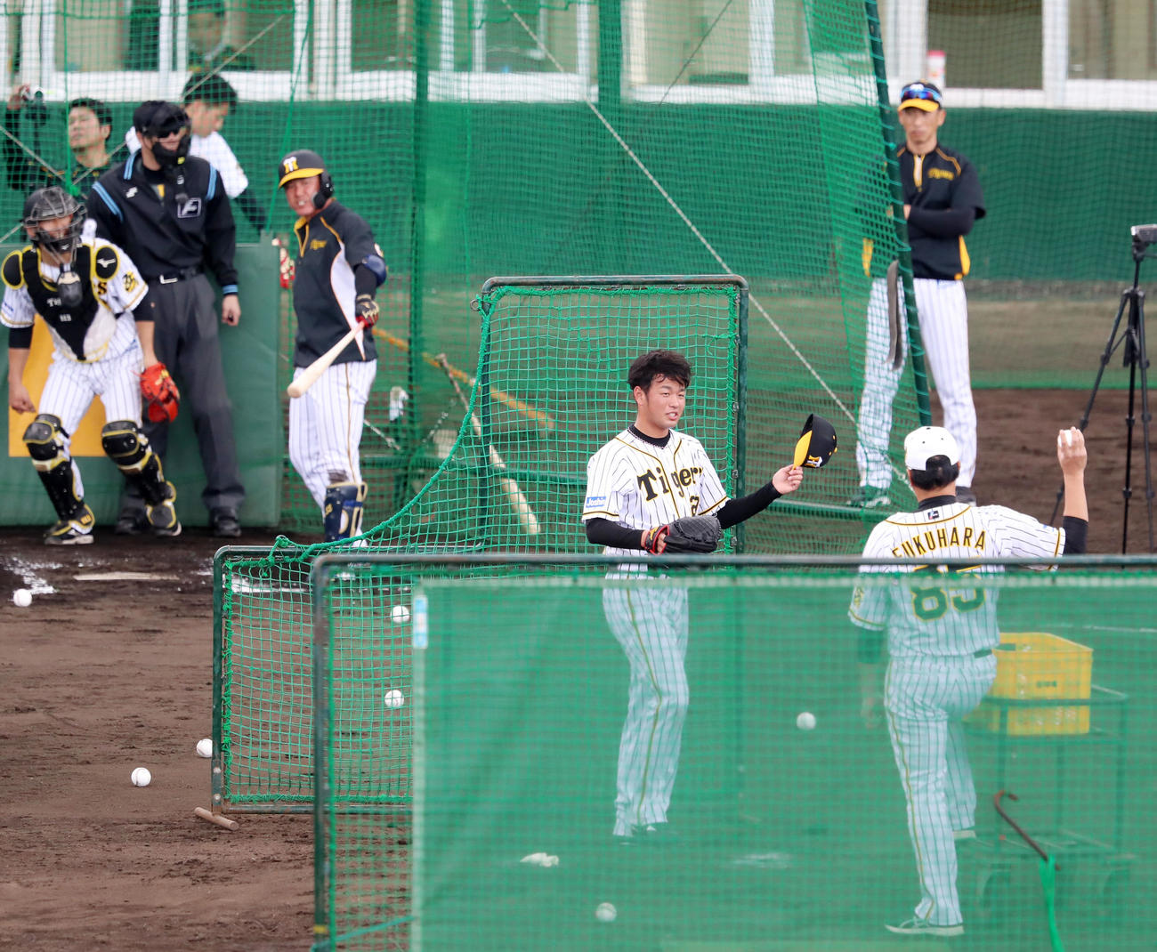 打撃投手で登板した阪神高橋遥人は投球を終え帽子を取る、右奥は矢野監督（撮影・加藤哉）