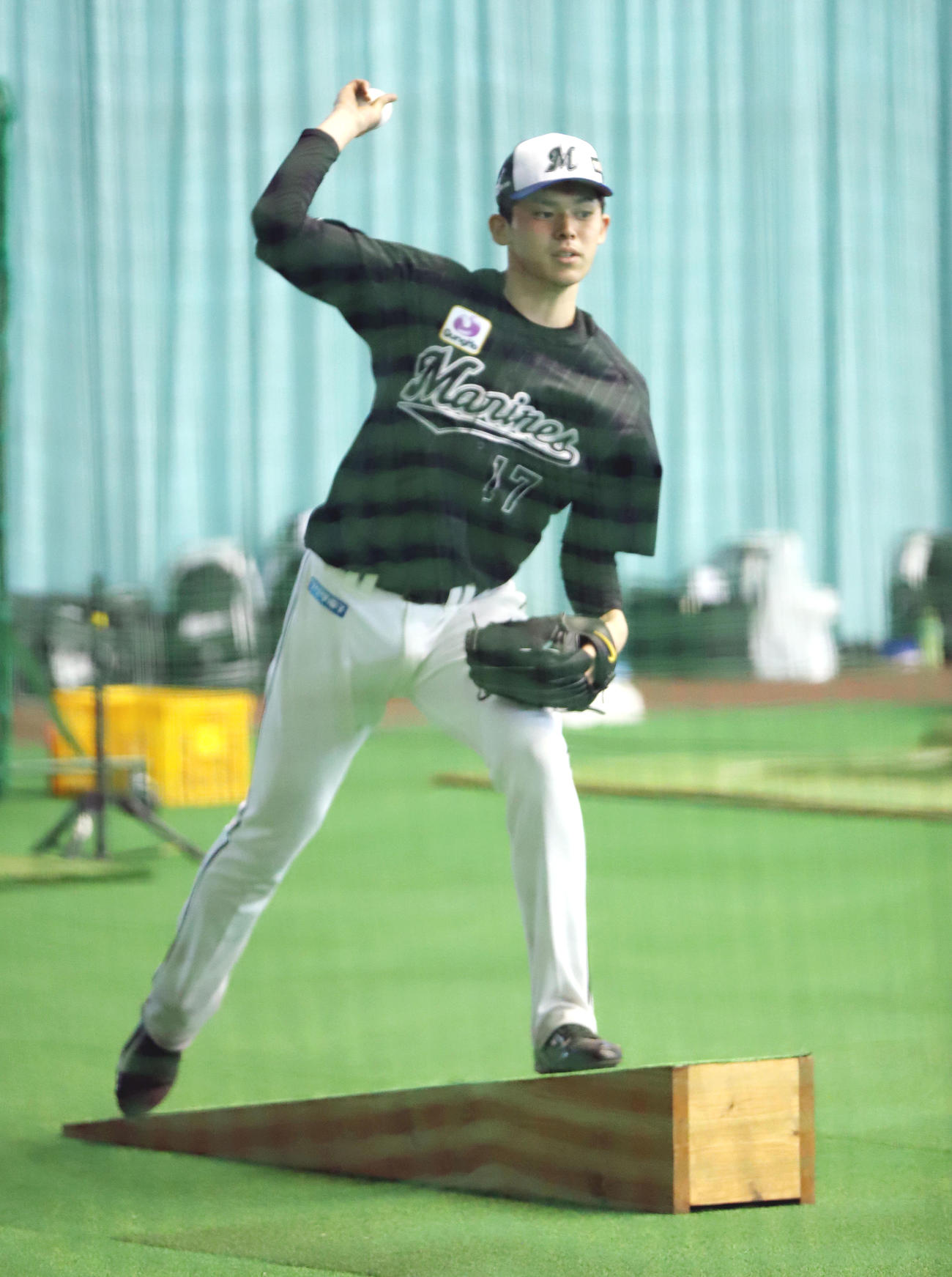 室内練習場で傾斜台に乗ってネットスローするロッテ佐々木朗（撮影・垰建太）