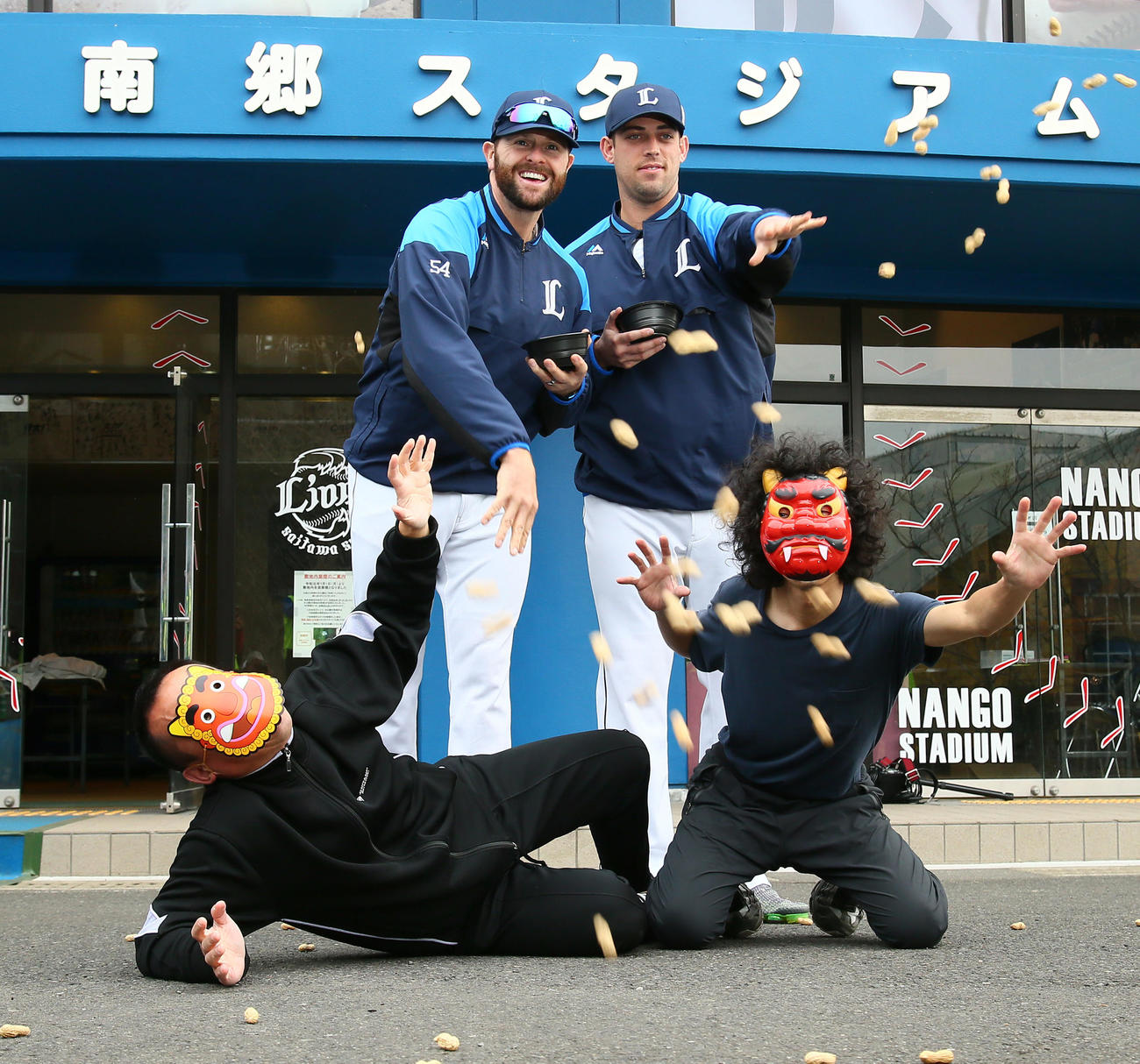 節分の豆まきを行う西武のニール（後方左）とノリン（同右）。手前右は鬼に扮する本紙河田カメラマン（撮影・足立雅史）