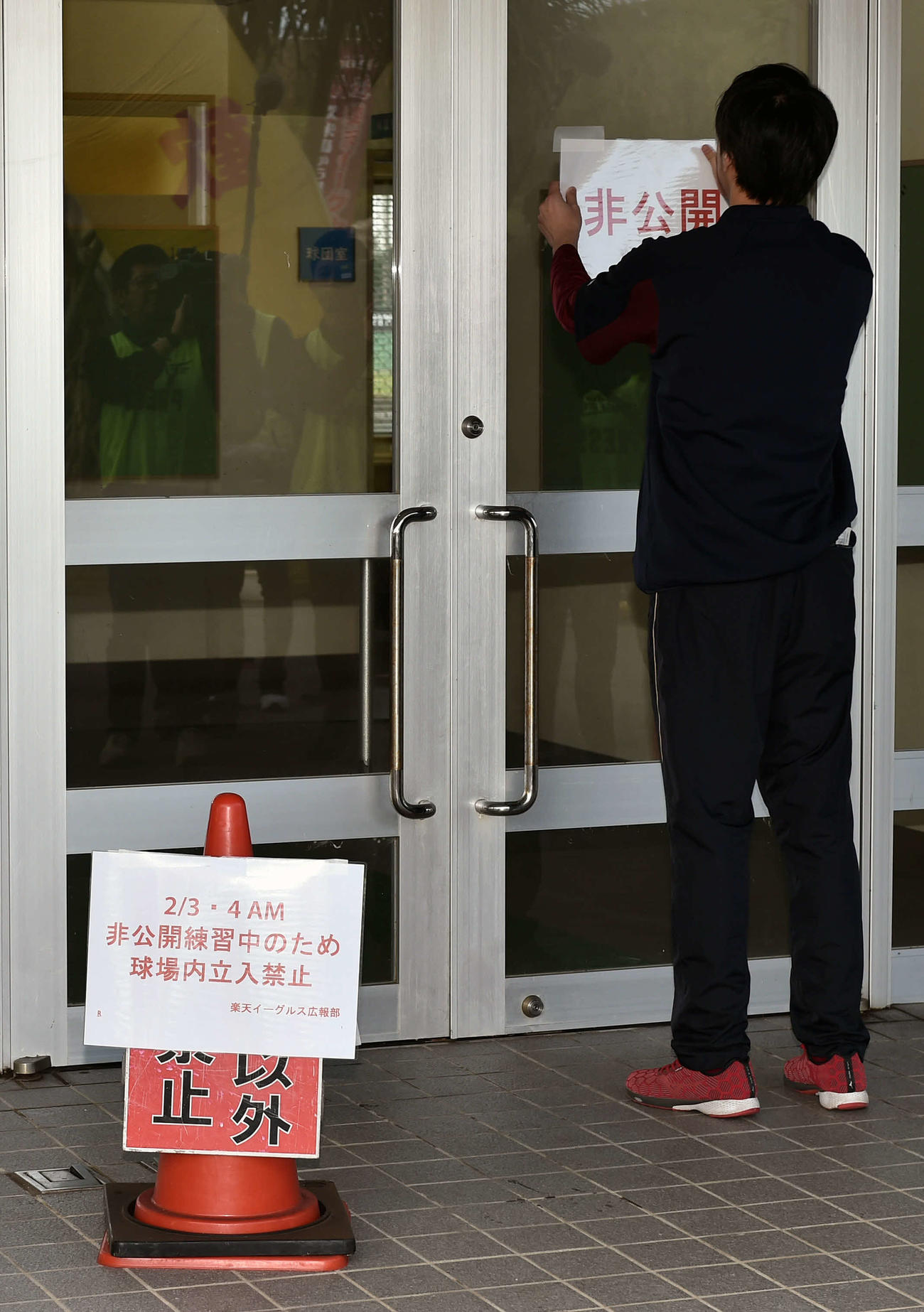 非公開の張り紙を貼る球団スタッフ（撮影・滝沢徹郎）