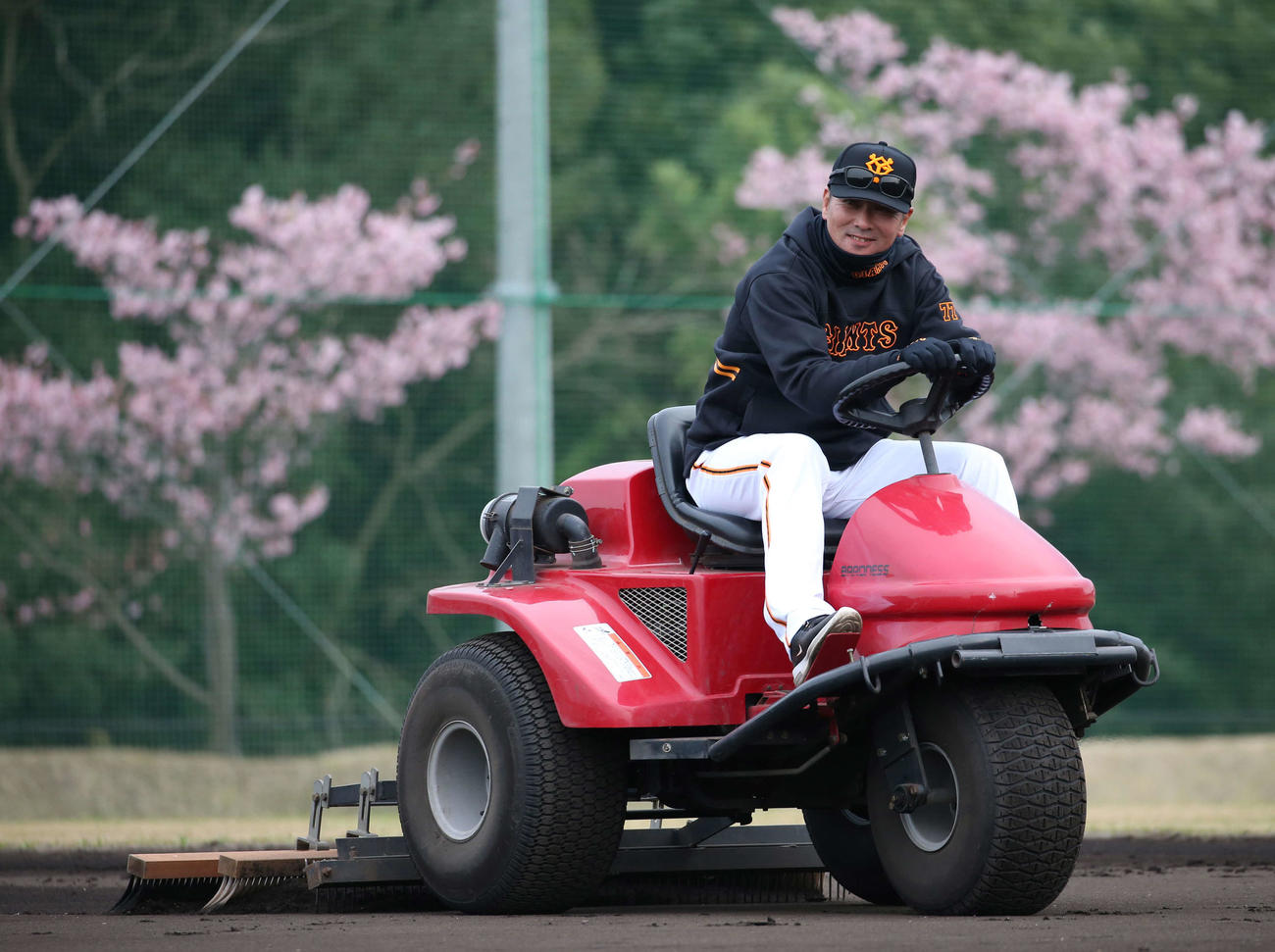 笑顔でグラウンドをならす巨人元木コーチ（撮影・河野匠）