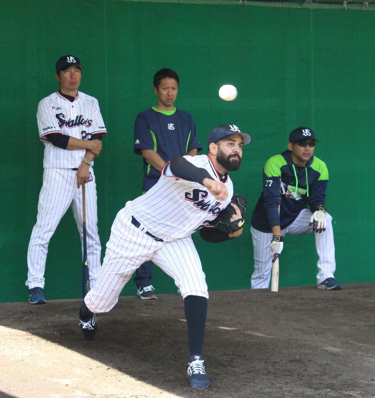 初めてブルペンに入り、高津監督（左端）と斎藤投手コーチ（右端）の前で投球するヤクルト・イノーア（撮影・保坂恭子）