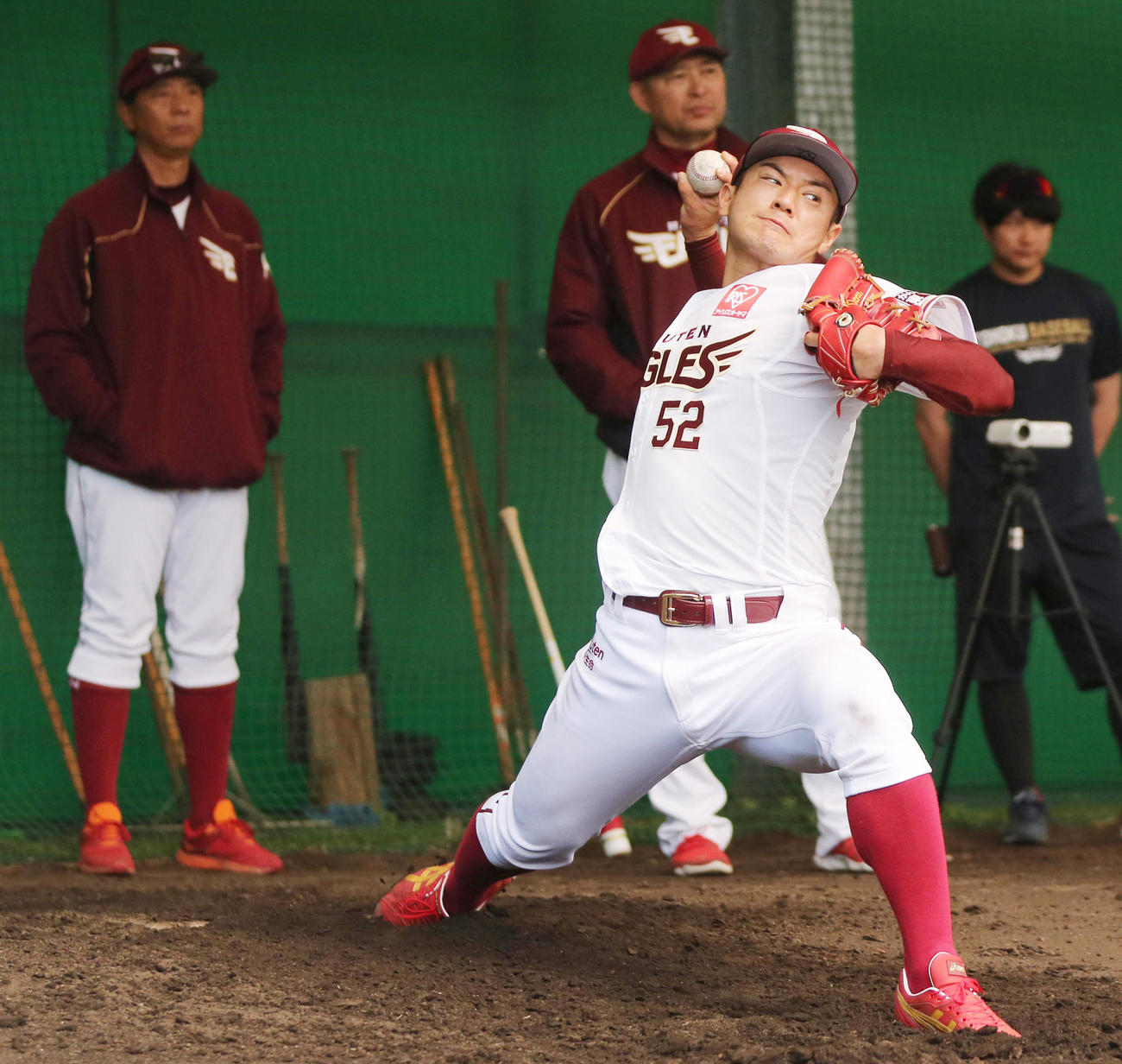 伊藤投手チーフコーチ（後方左）、光山バッテリー兼守備戦略コーチ（同右）が見つめる中、ブルペンで投球する楽天津留崎