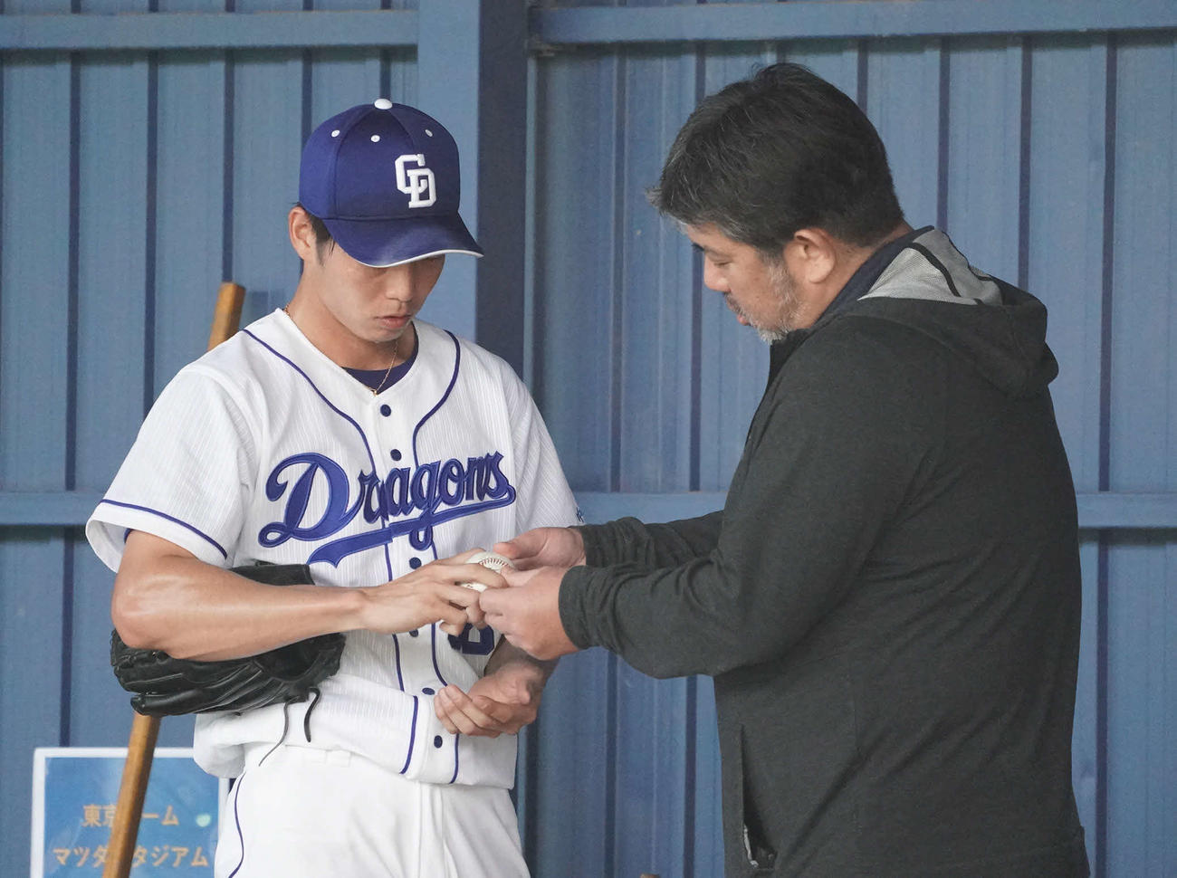 ブルペンで投球練習をする中日木下（左）にアドバイスを送る野茂氏（撮影・森本幸一）