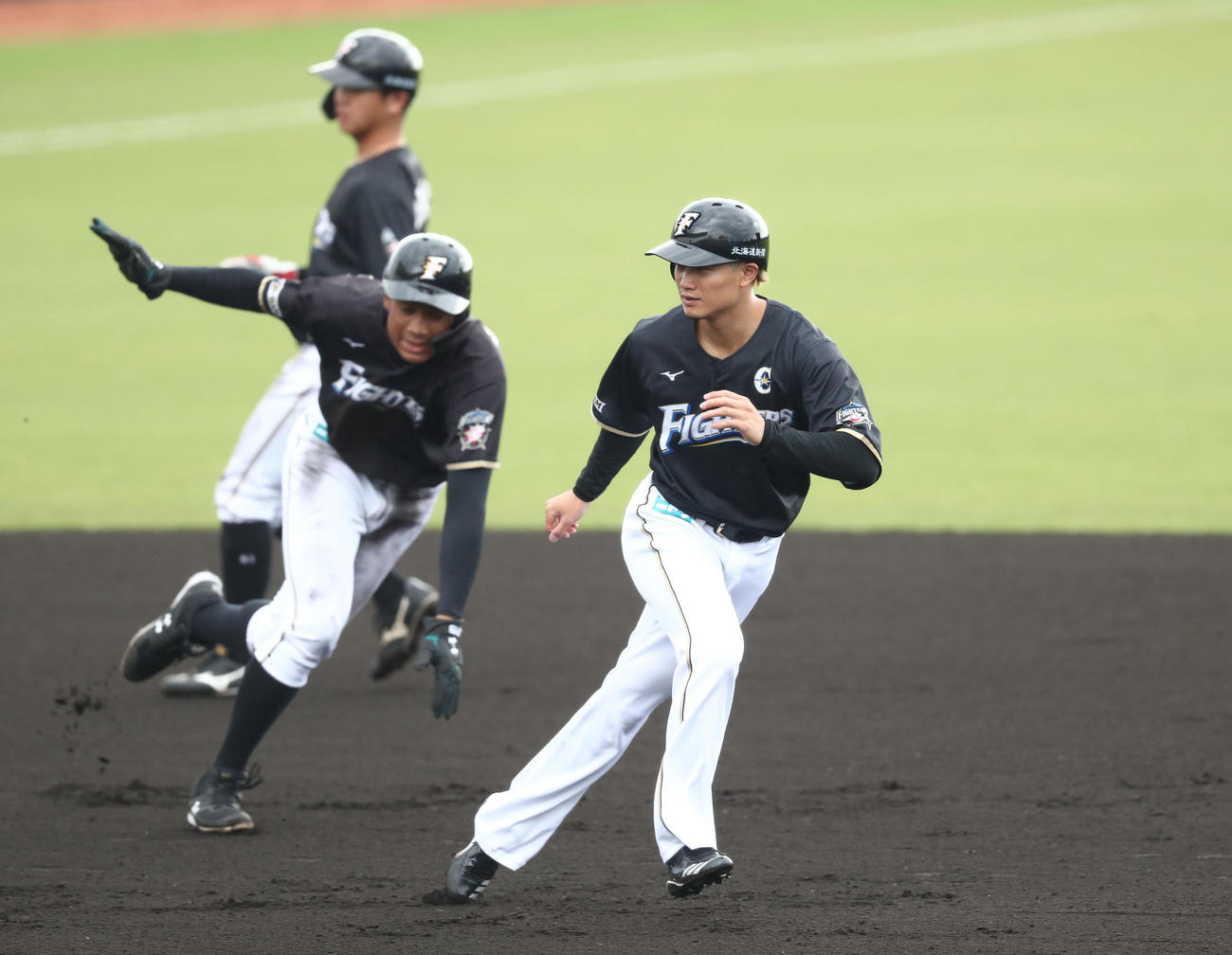 数人のグループで走塁練習する日本ハムの選手たち。右は西川（撮影・黒川智章）