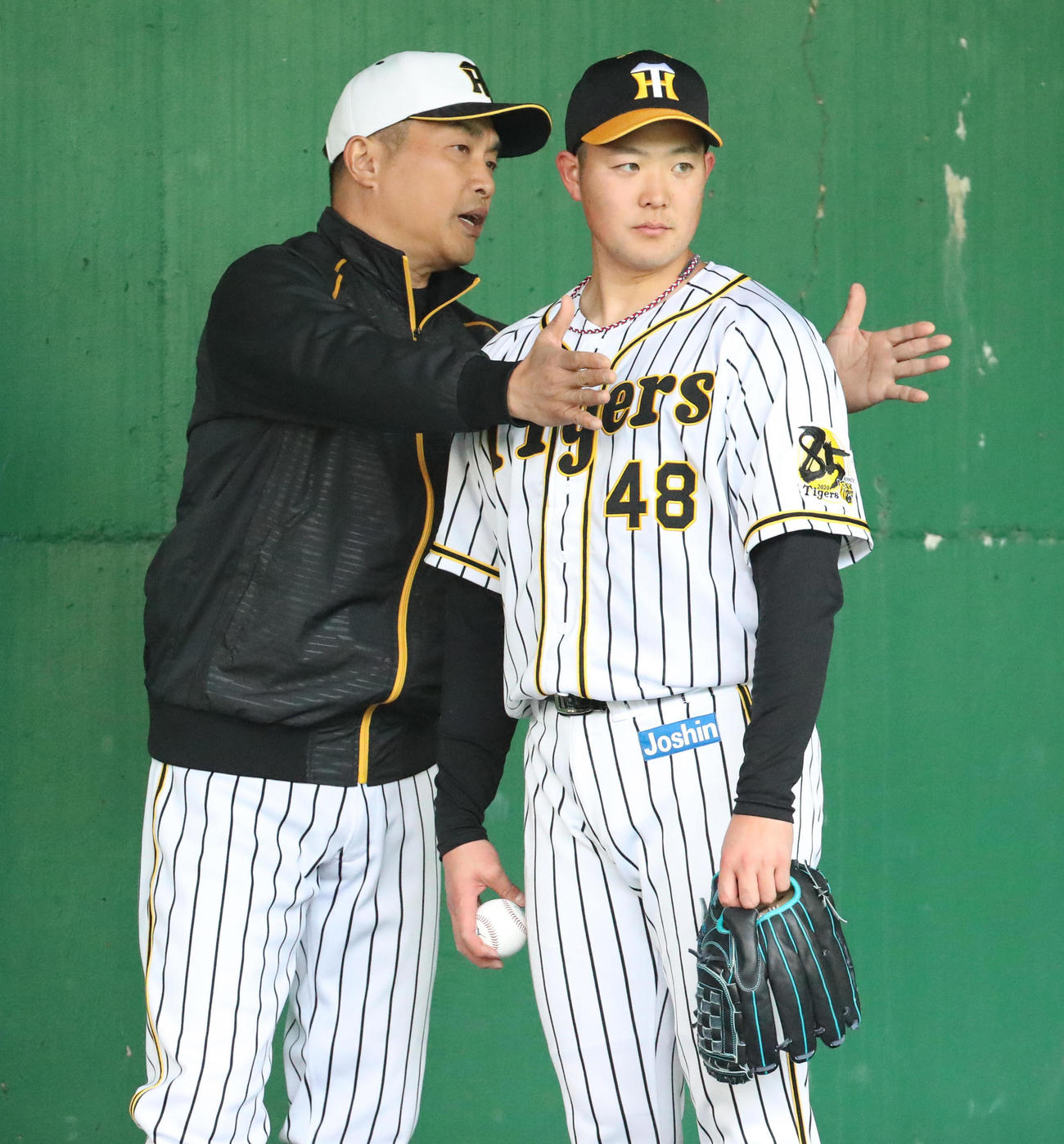 ブルペンで山本昌臨時投手コーチ（左）から指導を受ける斎藤（撮影・清水貴仁）