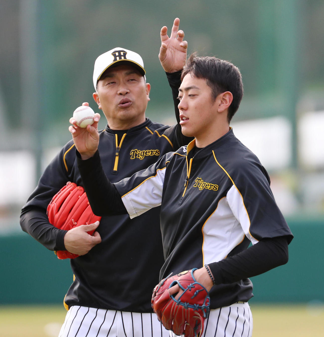 ルーキー小川一平（右）にチェンジアップの指導を行う山本昌臨時投手コーチ（撮影・清水貴仁）