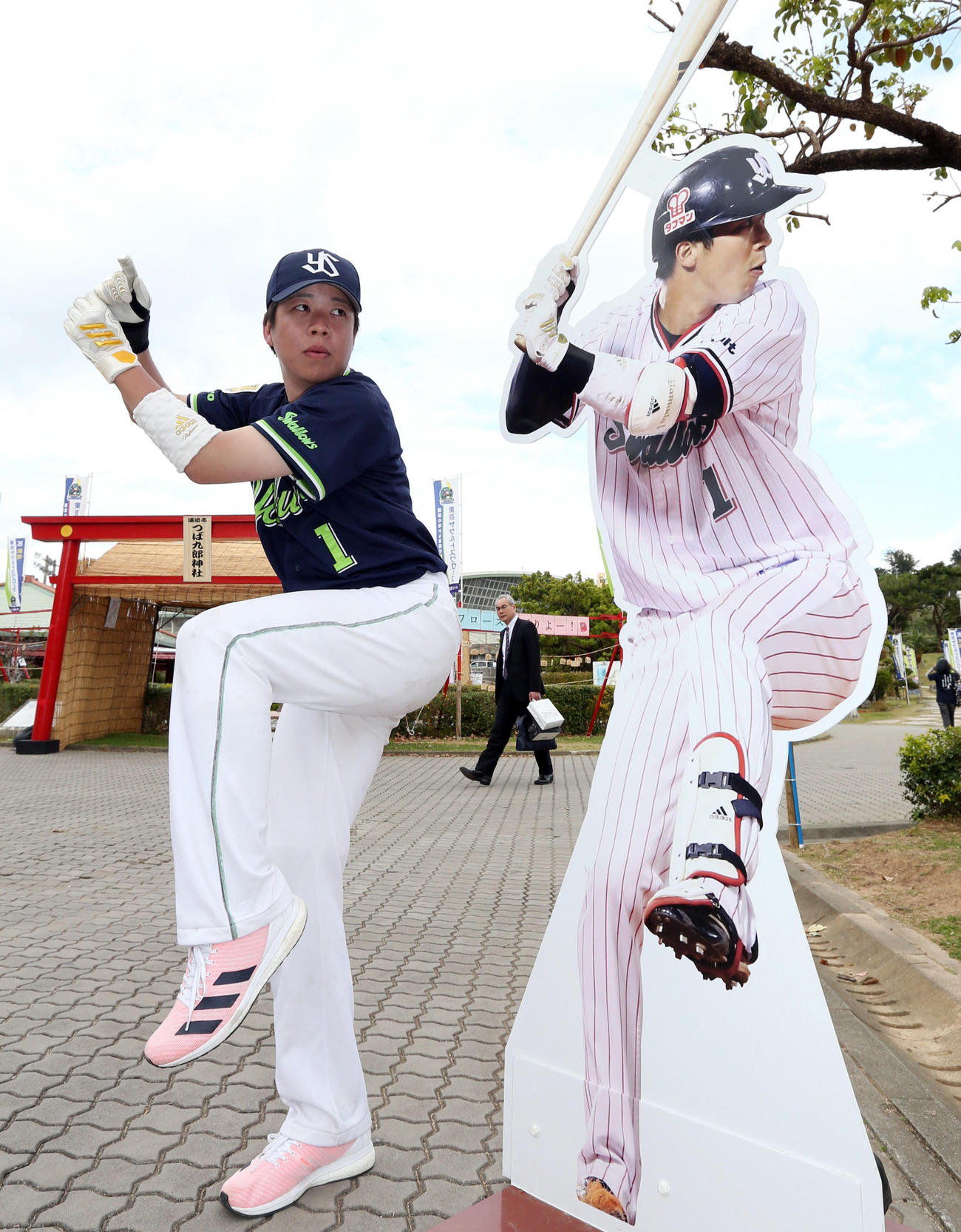 キャンプ地浦添に飾られている山田哲人パネルに並んで打撃フォームを披露するそっくりさん山田別人（べつと）（撮影・狩俣裕三）