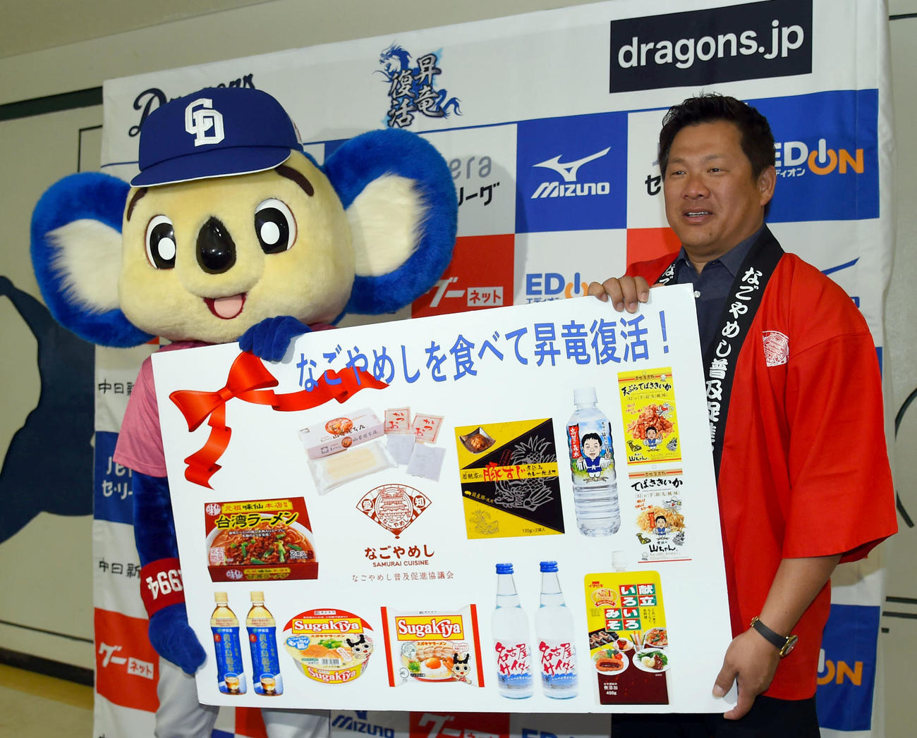 なごやめし応援大使の山崎武司さん（右）から「なごやめし」の差し入れを代表で受け取った中日ドアラ（撮影・森本幸一）